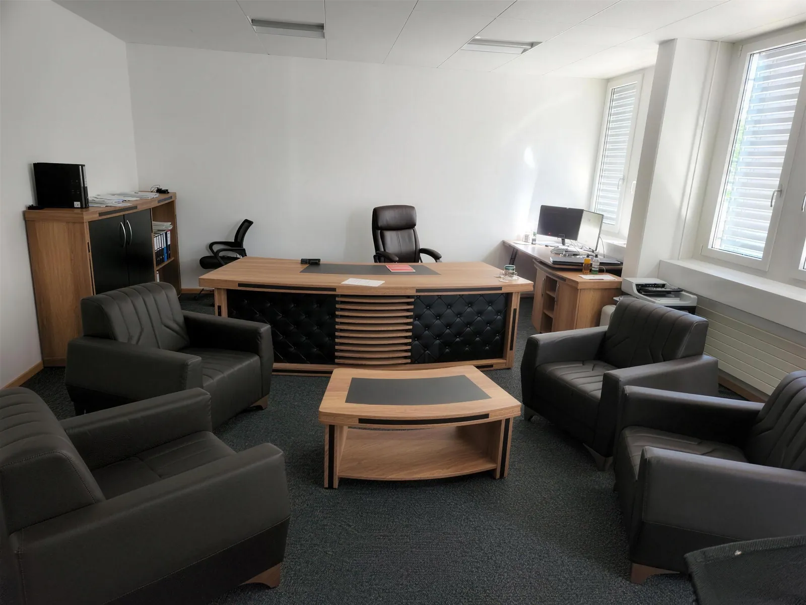 Executive office with desk, coffee table and leather lounge seating